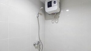 Een douche met een digitaal bedieningspaneel, een handdouche en een wandmengkraan.