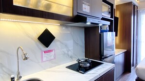 Une cuisine moderne équipée d’une cuisinière intégrée, d’un évier en acier inoxydable et d’un four à micro-ondes.