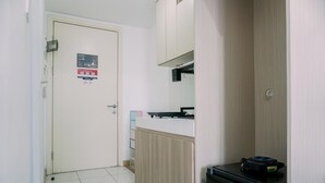 Eine kleine Küche mit Kühlschrank, Arbeitsplatte und einer Tür mit einem Schild.