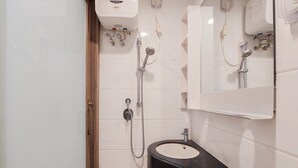 A bathroom with a black sink, a mirror, and a shower with a handheld showerhead. - Homey And Cozy Studio Sky House Bsd Apartment Near Aeon (Pagedangan)