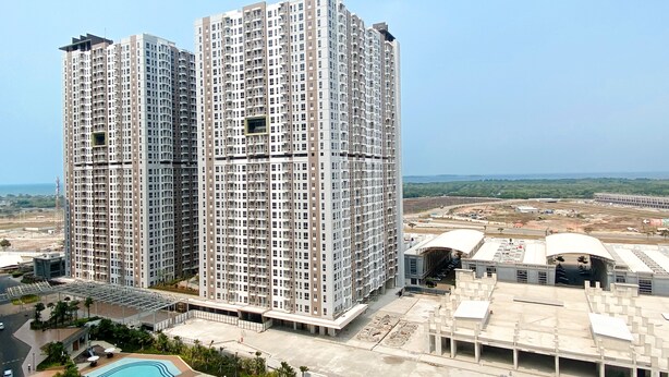 A high-rise residential building with multiple balconies, a swimming pool, and a landscaped area. - Furnished Studio For 3 Pax With Sofa Bed At Tokyo Riverside Pik 2 Apartment (Teluknaga)