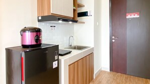 Una cocina compacta equipada con refrigerador, microondas y pileta.