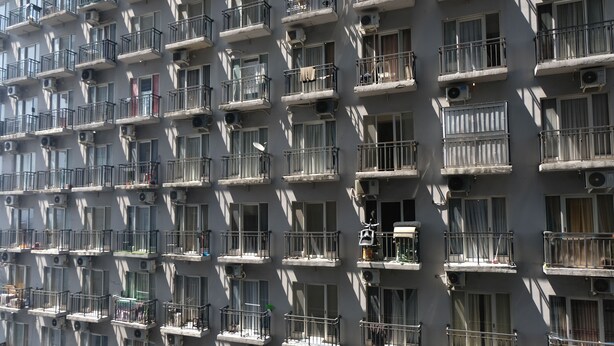 A multi-story building with numerous balconies, air conditioning units, and windows. - Minimalist Studio At Grand Asia Afrika Apartment (Bandung)