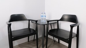 A small table with two chairs and two water bottles. - Minimalist Studio At Grand Asia Afrika Apartment (Bandung)