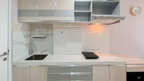 A modern kitchen with a built-in dishwasher, a sink with a faucet, and a microwave on the countertop.
