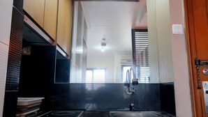 A kitchen with a black countertop, a sink, and a stove.