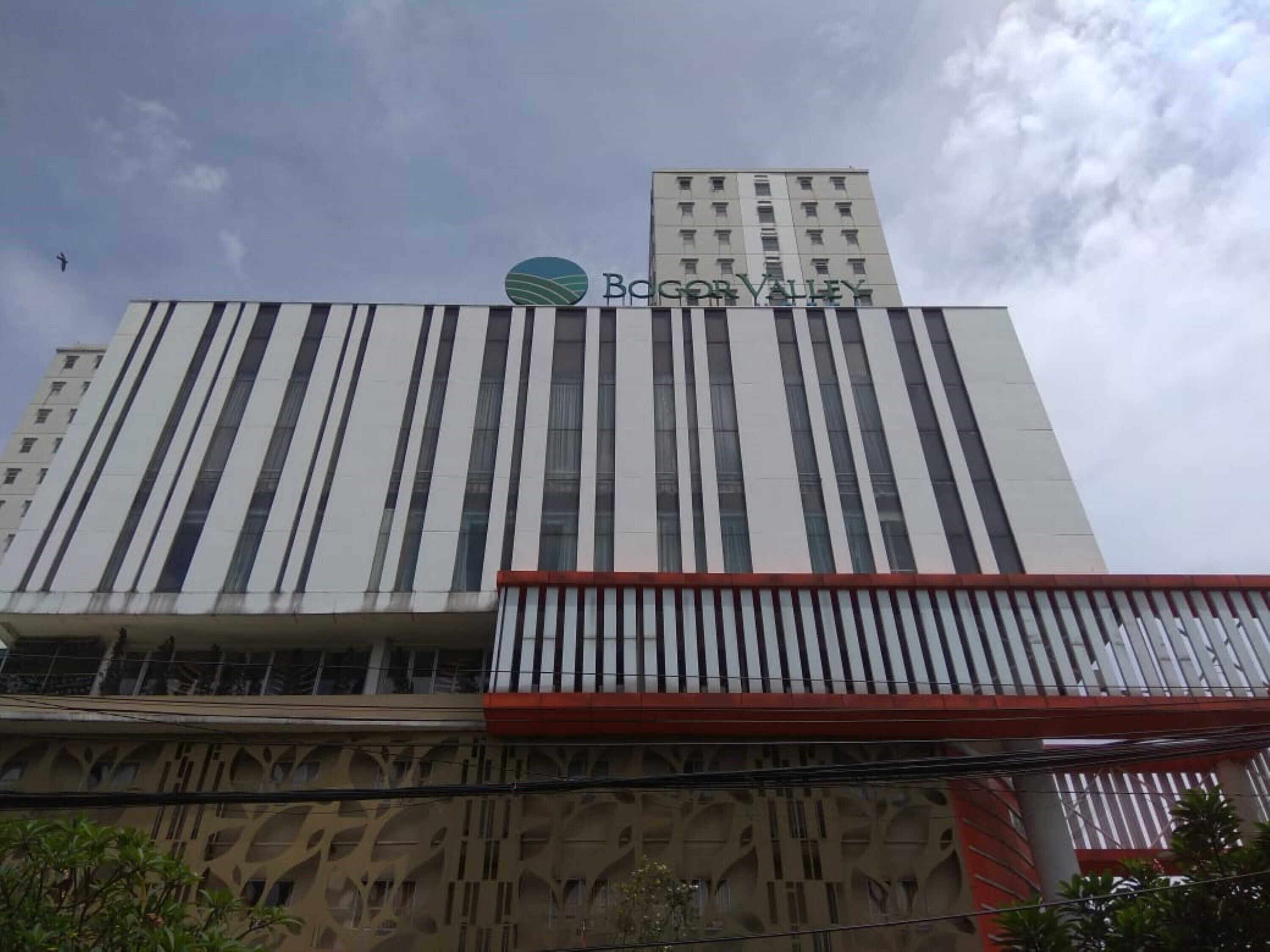 A building with a modern design, featuring vertical stripes and a prominent logo at the top.