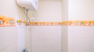 A bathroom with white tiles, a showerhead, and a wall-mounted heater.