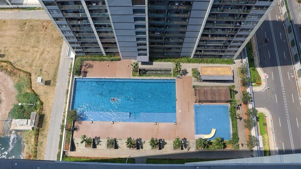 A high-rise building with a rooftop swimming pool and a landscaped area. - Spacious And Homey Studio At Daan Mogot City Apartment (Jakarta)
