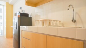 Une cuisine équipée d’un réfrigérateur, d’un évier et d’un plan de travail avec un égouttoir à vaisselle.