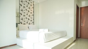 Une chambre à coucher moderne avec un lit, un miroir et une porte en bois.