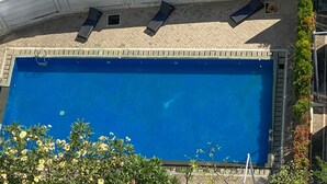 A rectangular swimming pool with a tiled deck and a metal railing. - Best Choice And Homey Studio Tifolia Apartment (Jakarta)
