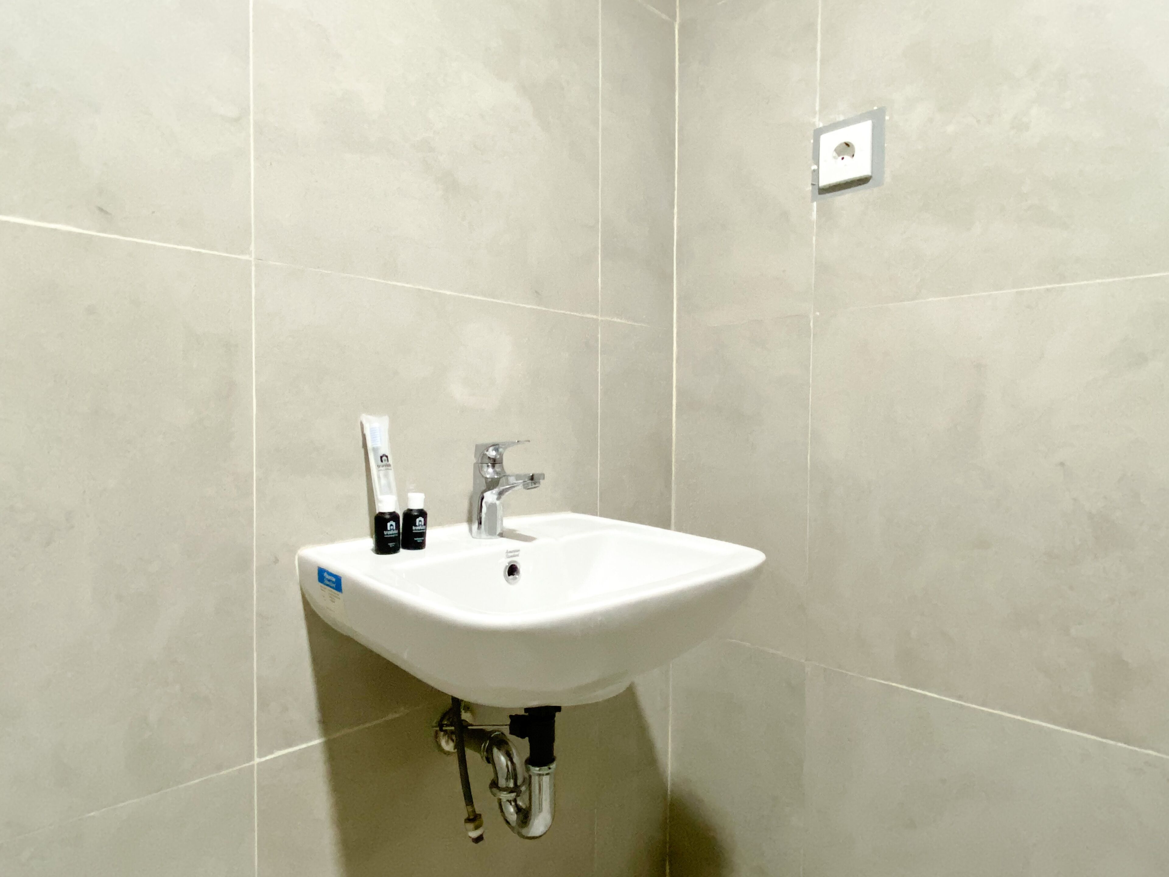 A bathroom with a white sink, a mirror, and a faucet.
