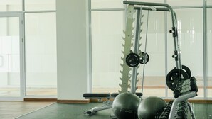 A gym with weightlifting equipment, a bench, and exercise balls.