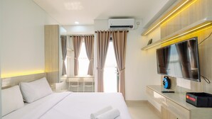 Una habitación de hotel moderna con una cama grande, televisión, escritorio y una silla.
