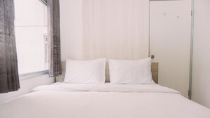 A single bed with white bedding in a room with a window and a door. - Stunning And Homey 2Br Green Bay Pluit Apartment (Jakarta)