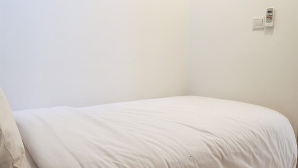 A simple, unadorned room with a bed and a wall-mounted telephone. - Comfortable Stay 2Br Apartment At Tokyo Riverside Pik 2 (Teluknaga)