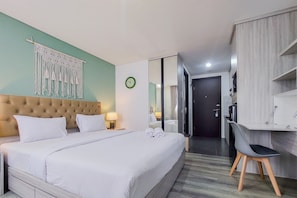 Relax in a spacious room with a large bed, tufted headboard, and minimalist decor.