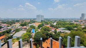 A high-rise building with a modern design, surrounded by a mix of residential and commercial buildings, and a clear sky. - Best Homey And Nice Studio At Bintaro Icon Apartment (South Tangerang)