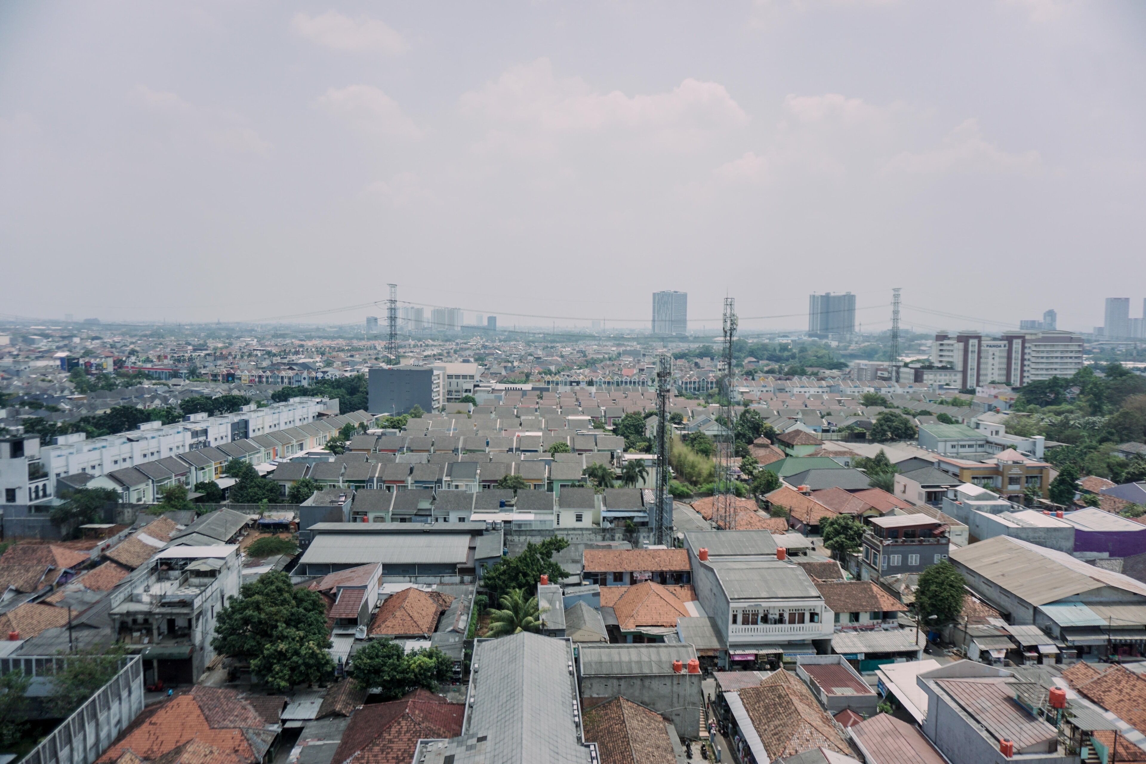 A densely packed urban area with numerous buildings, some with flat roofs and others with sloped roofs.
