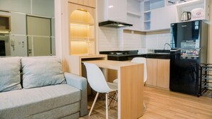 A compact living space with a kitchenette, a sofa, and a dining area. - Modern Look 2Br Apartment M-Town Residence (Gading Serpong)
