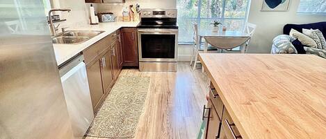 A modern kitchen with wooden cabinets, stainless steel appliances, and a large island.