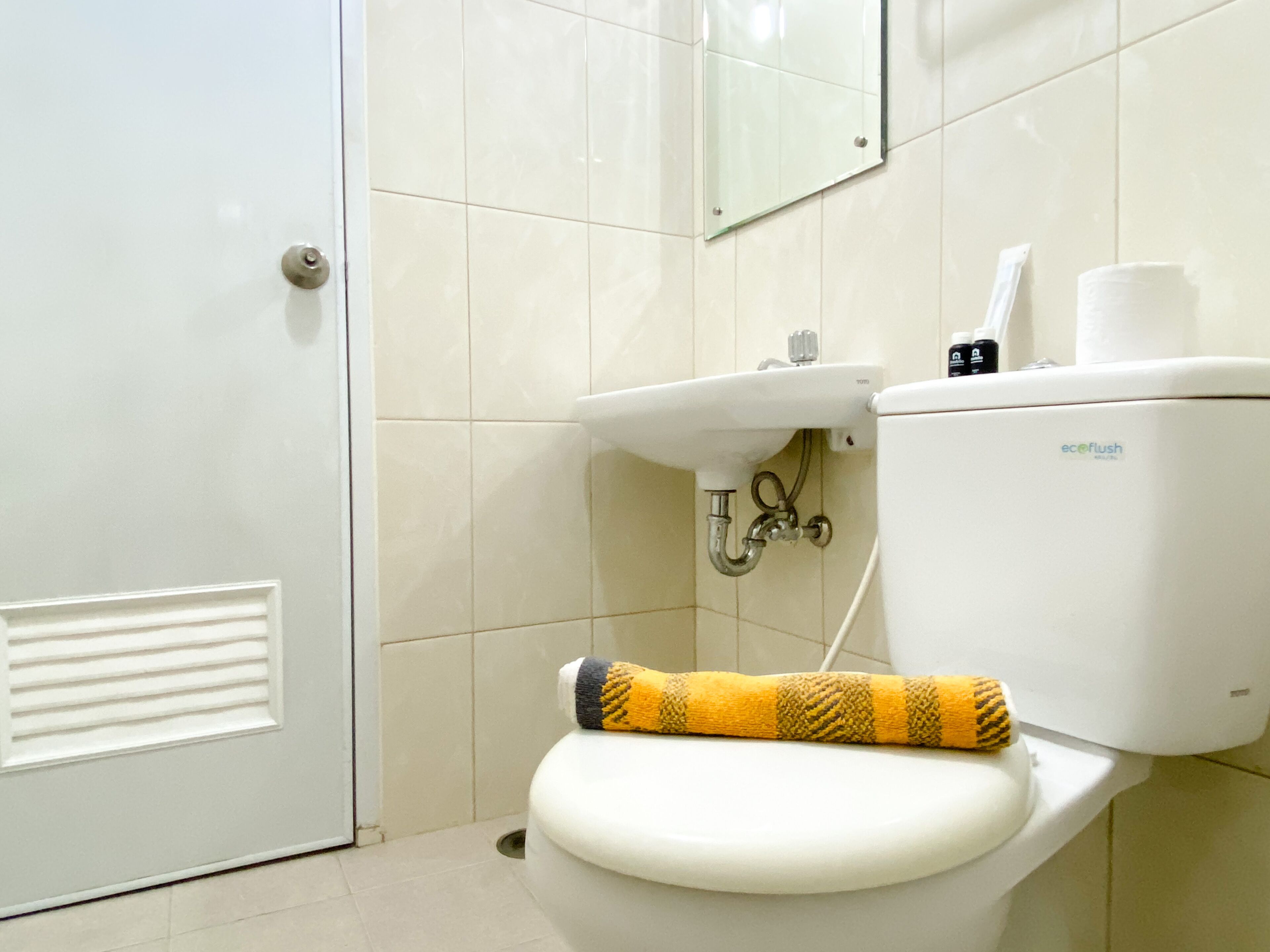 Une salle de bain avec des toilettes, un lavabo et un miroir.