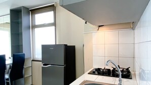 Et moderne køkken med en stålvask, et sort køleskab og en gaskomfur.