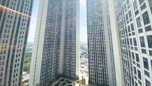 A high-rise building with a grid-like facade and multiple windows. - Comfort Stay Studio Room Pollux Chadstone Apartment (Cikarang)
