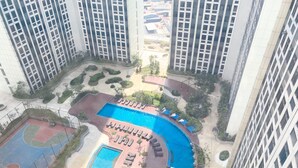 A high-rise building with a swimming pool, basketball court, and lounge area. - Comfort Stay Studio Room Pollux Chadstone Apartment (Cikarang)
