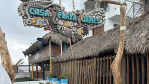 A building with a sign reading "CASA PLAYA JAMES" and a thatched-roof structure. - Casa Playa James  (Cartagena)