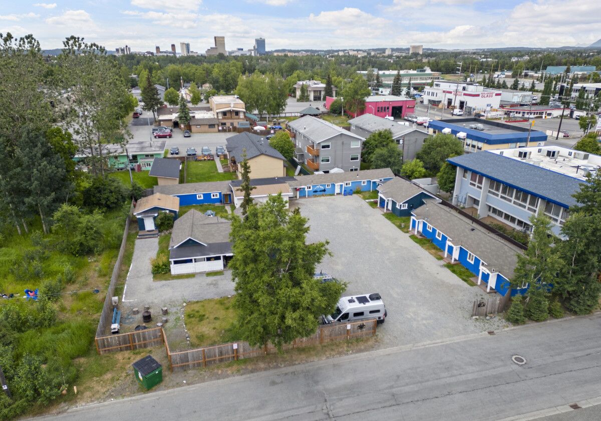 A residential area with houses, a parking lot, and a small commercial building.