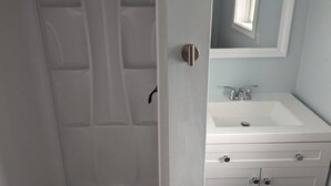 Une salle de bain avec une porte blanche, un lavabo et un miroir.