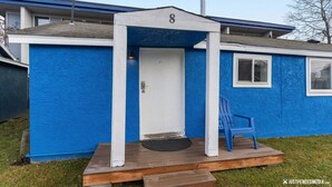 A small, single-story building with a blue exterior, a white door, and a number '8' above the door. - Historic cottage - 10 minute walk to restaurants & trails (Anchorage)