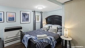 Un dormitorio con cama, mesita de noche y decoración en la pared.