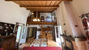 A spacious room with a high wooden ceiling, a dining area with a table and chairs, and a balcony with a railing. - 085 - Invitation to rest in this villa in Grande Combe (SOULAC SUR MER)