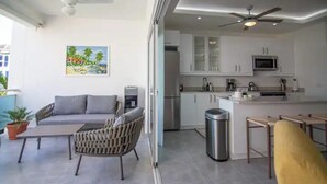 A modern kitchen with white cabinets, a microwave, and a stainless steel refrigerator. - 3BR Renovated Beachfront Condo + Cooking/Cleaning (Las Terrenas)