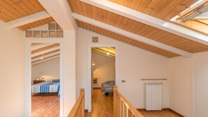 A wooden staircase leading to a bedroom with a bed and a radiator. - Holiday Home "Casa Flora" with Private Pool, Private Terrace and Wi-Fi (Monteverdi Marittimo)