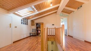 A spacious room with wooden floors, a skylight, and a staircase with a wooden railing. - Holiday Home "Casa Flora" with Private Pool, Private Terrace and Wi-Fi (Monteverdi Marittimo)
