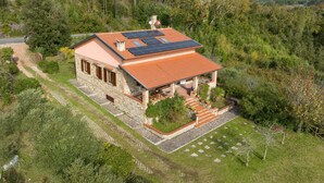 A stone house with a red-tiled roof, solar panels, and a stone staircase leading to a covered porch. - Holiday Home "Casa Flora" with Private Pool, Private Terrace and Wi-Fi (Monteverdi Marittimo)