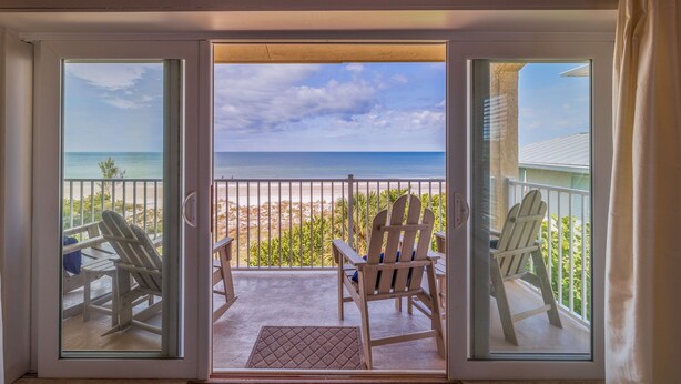 A balcony with a view of the beach and ocean. - 10 Pipers III – Beachfront Bliss with Ocean Views, Private Balcony & Grill Area (Indian Rocks Beach)