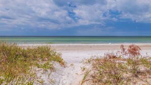 A beach with clear skies and calm waters. - 10 Pipers III – Beachfront Bliss with Ocean Views, Private Balcony & Grill Area (Indian Rocks Beach)