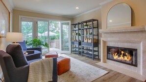 Un salon avec une cheminée, un canapé, une table basse et une bibliothèque.