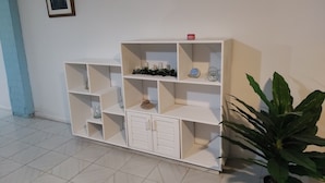 Une étagère blanche, dotée de plusieurs compartiments, dont certains contiennent des objets décoratifs.