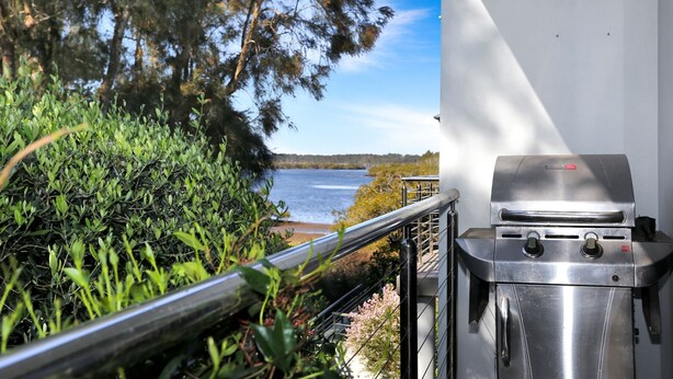 A grill with a view of a lake and surrounding vegetation. - 2 The Pier - Elegance by the Water (Tea Gardens)