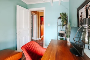 Een eethoek met een houten tafel en een rode fauteuil.