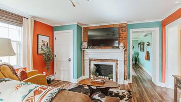 A living room with a fireplace, a television, and a sofa.