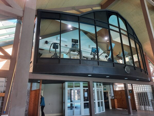 A modern building with a large glass enclosure, a staircase, and a view of exercise equipment. - Margarita Vacation Getaway (Oro-Medonte)