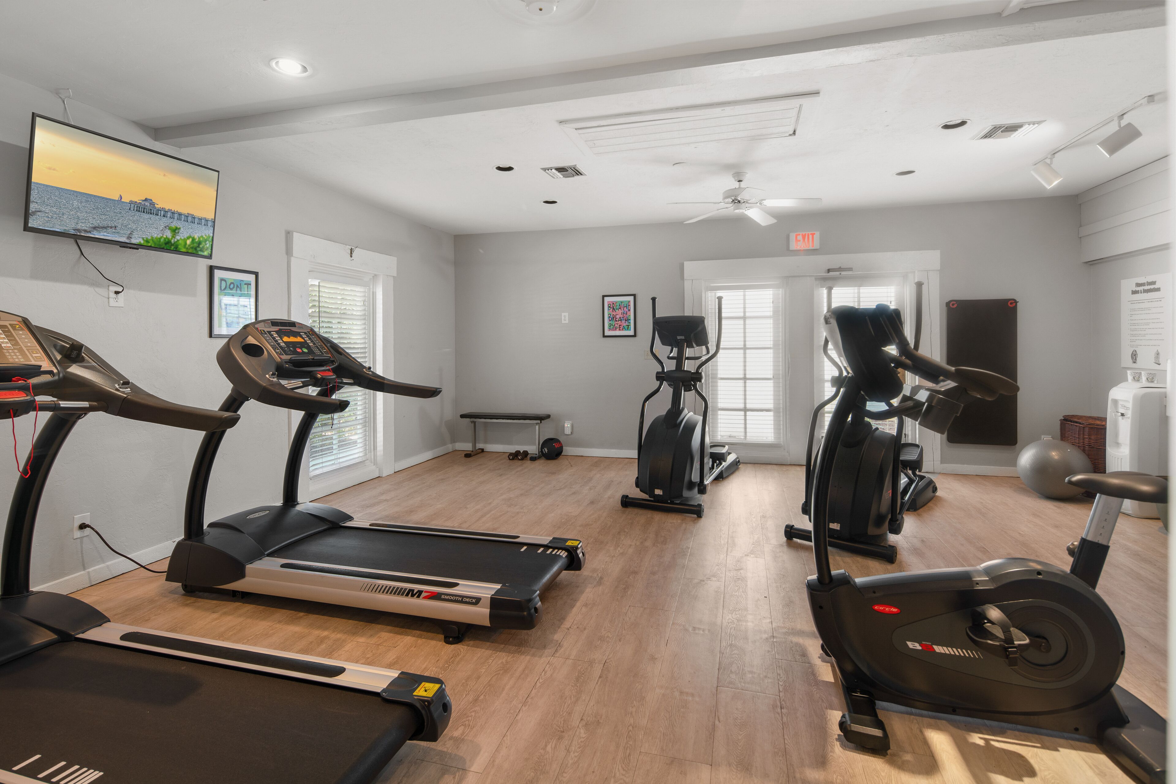 Une salle de sport équipée de tapis de course, d’un vélo elliptique et d’un vélo d’appartement.
