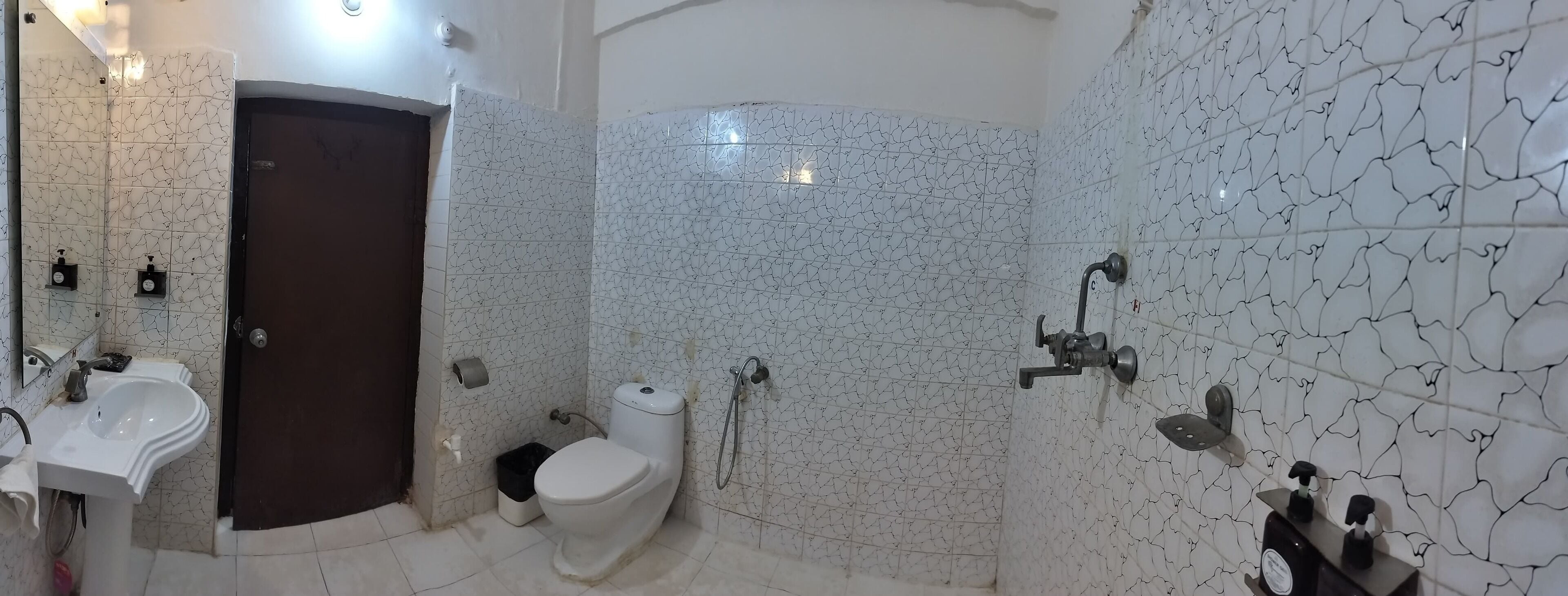 A bathroom with a white sink, toilet, and shower area.